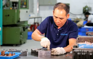 Experienced technician assembling precision metal molds for industrial hardware