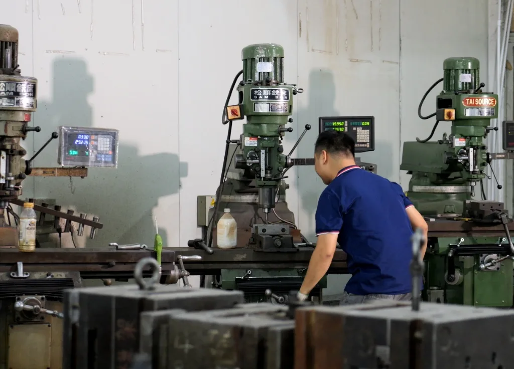 Factory technician operating a vertical milling machine for precision tool and die making