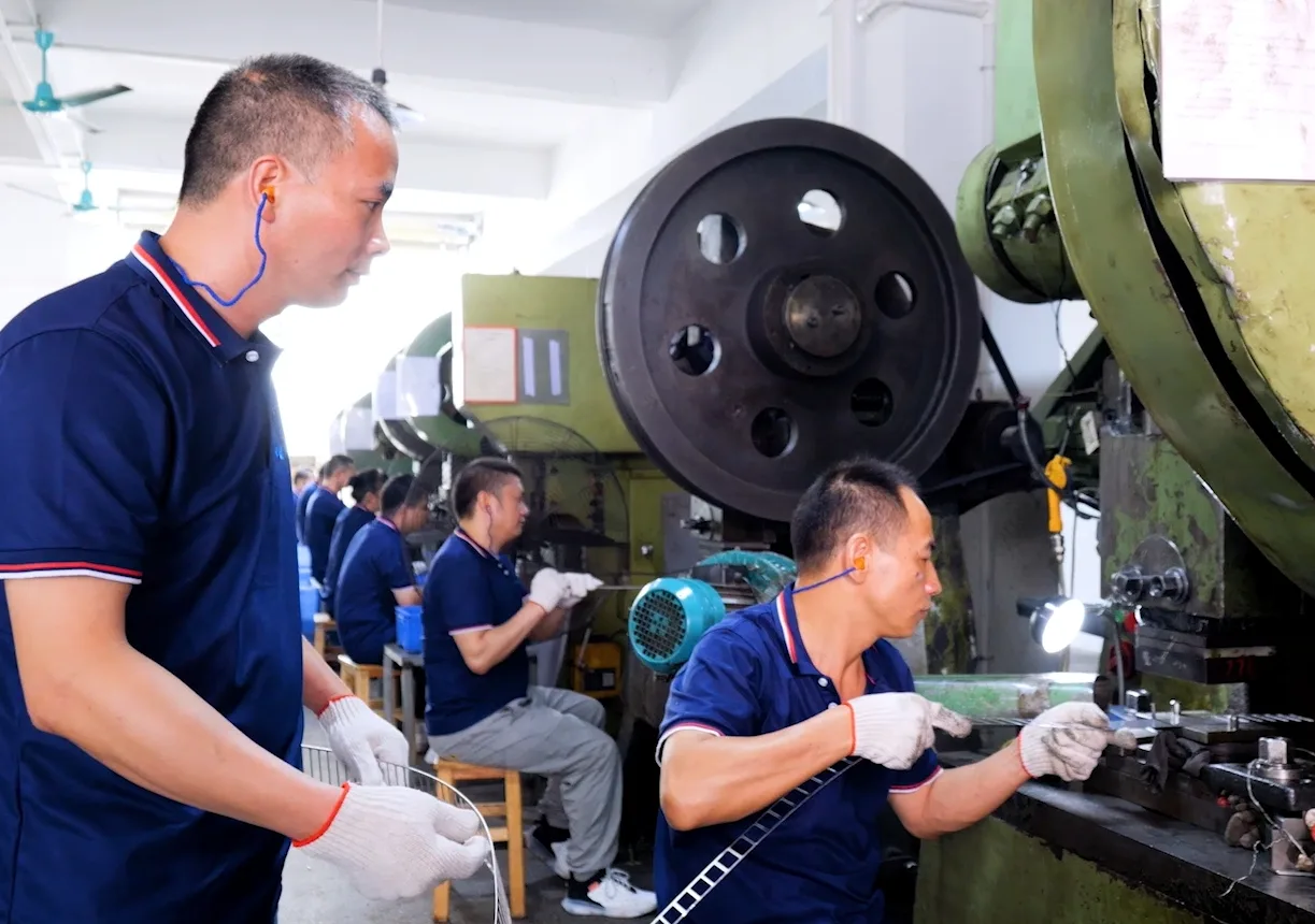 HSP technicians operating stamping presses for industrial hinge production