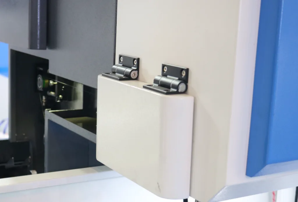 Paired hinges installed on a small access panel with a shared hinge axis