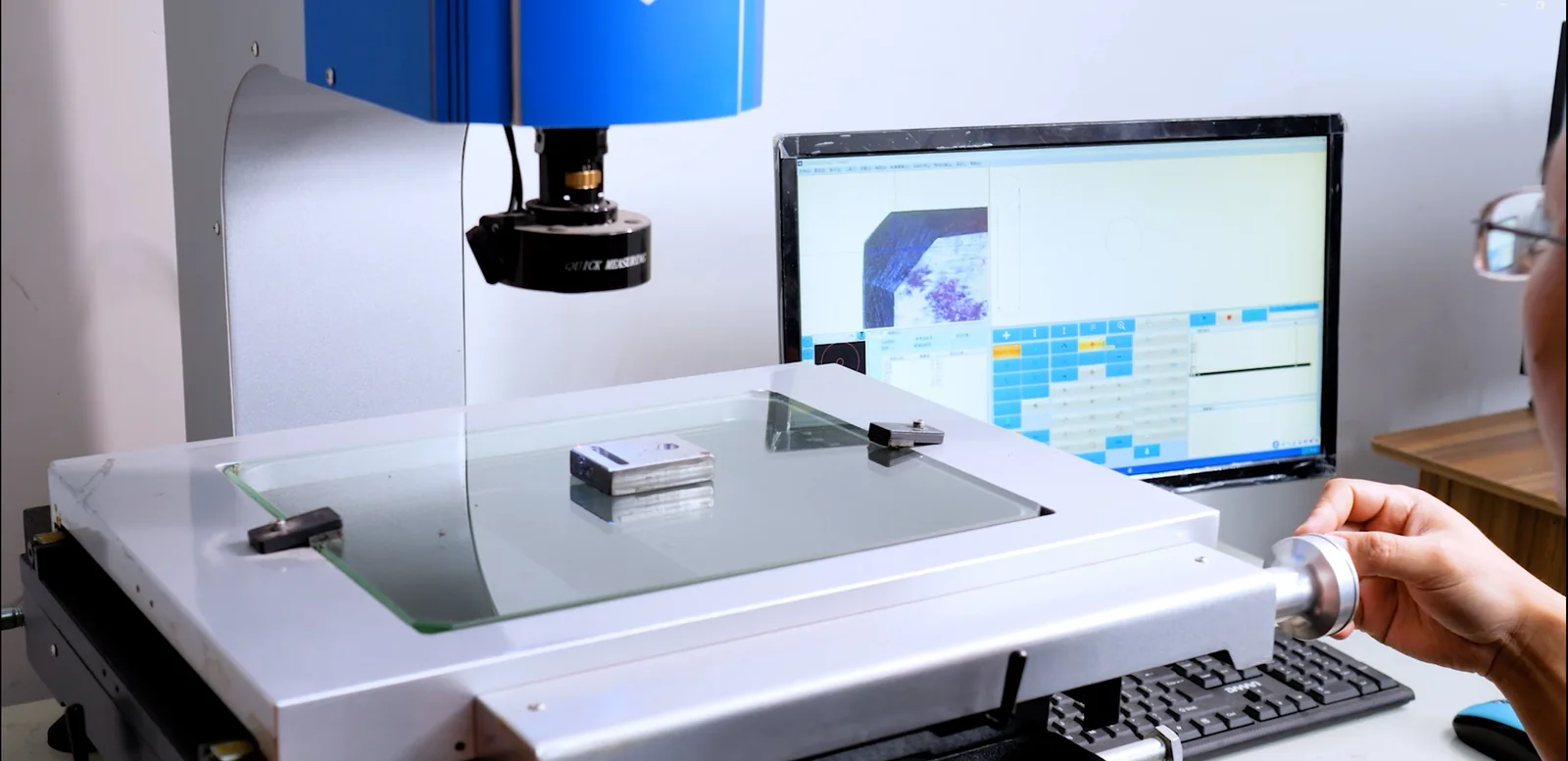HSP technician measuring a hinge component with a 2D optical inspection system