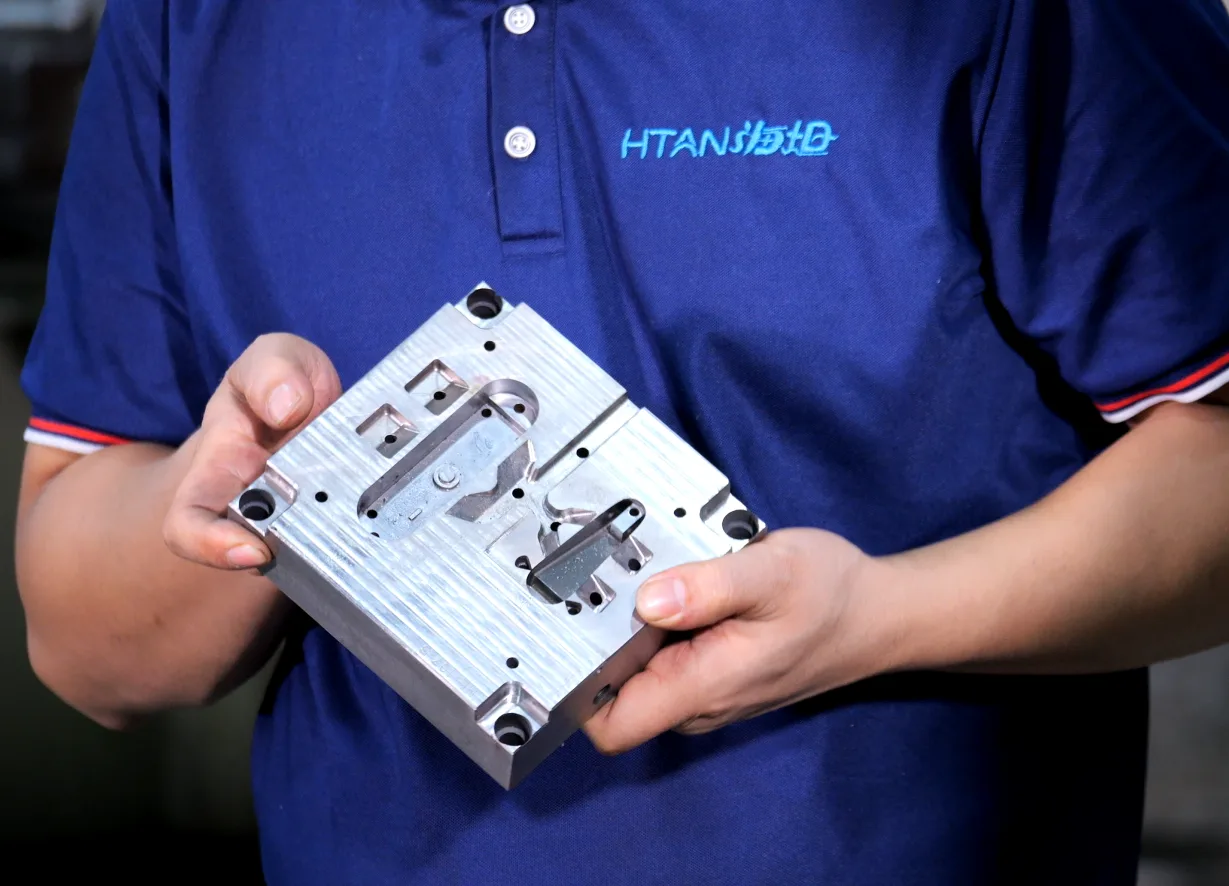 HSP technician presenting a custom hinge tooling mold for manufacturing review