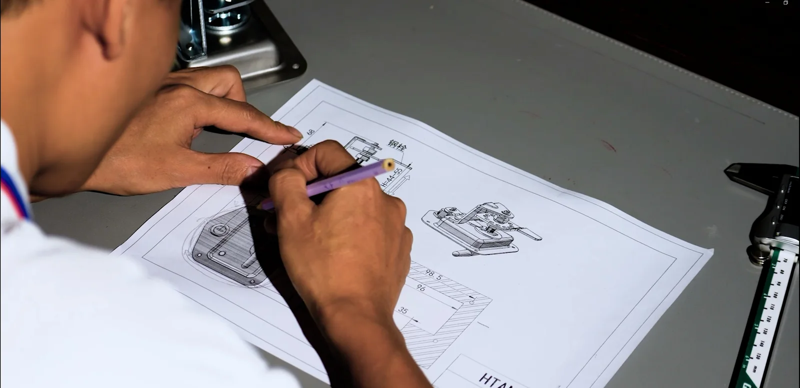 HSP engineer reviewing dimensions on an industrial hinge drawing