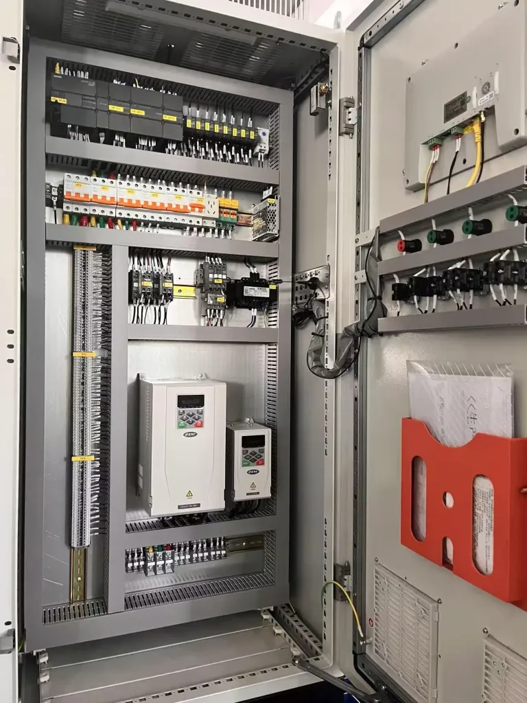 Open industrial control panel door with hinges, hinge-side wiring and door-mounted controls
